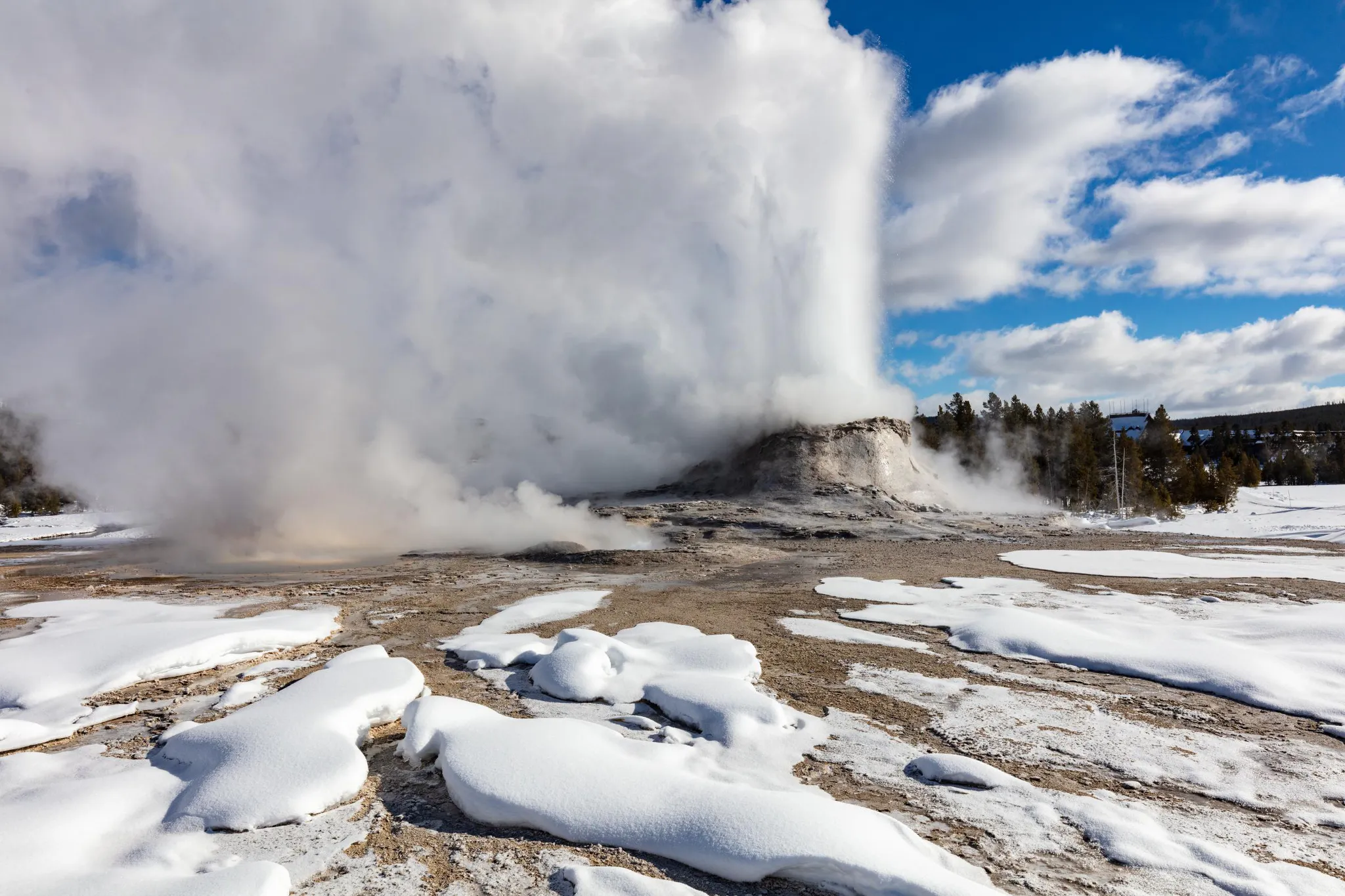 Castle Geyser in Yellowstone National Park erupts in on a clear day in winter