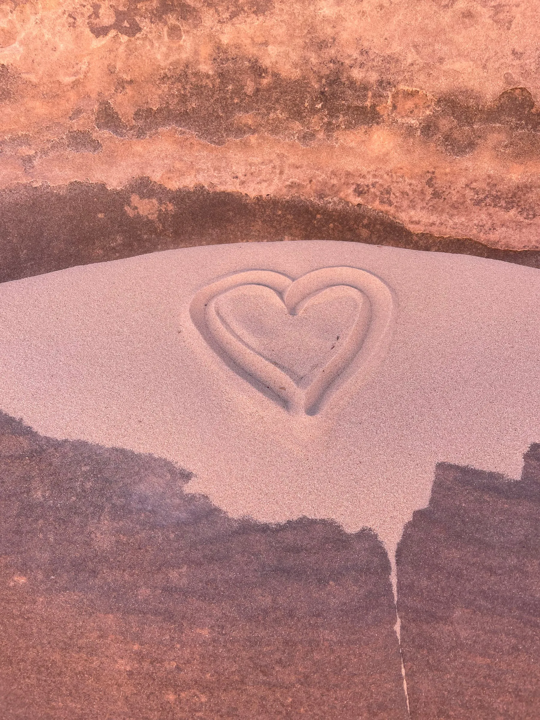 A heart drawn in the sand of a slot canyon floor